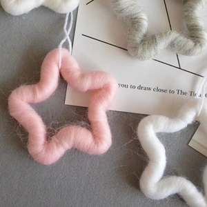 Handmade wool felt star ornaments in pink, white and grey for Christmas tree decoration