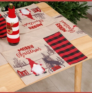 Close-up of festive Christmas placemats and wine bottle covers with gnome and reindeer patterns