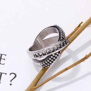 Artistic detail of silver woven ring with beads on dry branch background