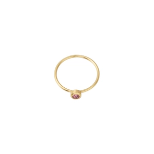Detail view of a minimalist gold band ring featuring a pink round-cut birthstone bezel setting