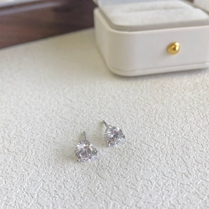 Macro shot of silver stud earrings featuring round clear cubic zirconia in four-claw setting