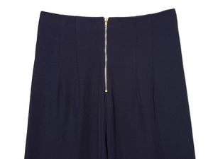 Vue détaillée du pantalon bleu foncé à taille haute avec fermeture éclair dorée et texture tissée