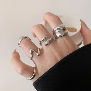 Close-up of 5-piece silver liquid metal ring set with organic irregular shapes and polished finish