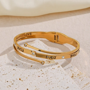 Three-layer gold spiral bracelet with LOVE engraving and crystals on stone base