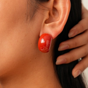 Close-up of bright red acrylic drop earring worn on model for a vintage look