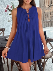 Detail of blue sleeveless pleated mini dress featuring a bow tie neckline and loose fit design