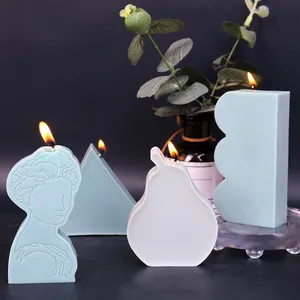Artistic geometric soy wax candles including portrait relief and pyramid shapes on dark background