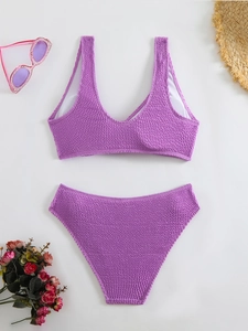 Detailed flat lay of lilac textured bikini set with summer hat and sunglasses
