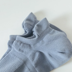 Detailed macro shot of the light blue knit sock showing the elastic ribbed cuff texture