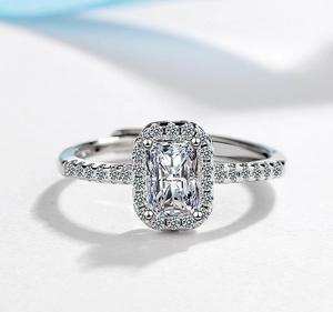 Macro shot of a radiant cut silver ring with a halo setting and adjustable open band