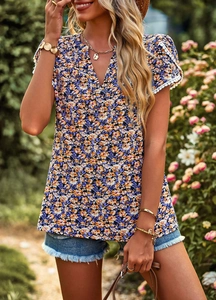 Detail of V-neck top showing orange and purple floral print and white lace sleeve cuffs