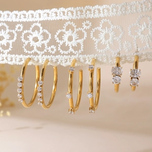 Three pairs of 18K gold-plated stainless steel hoop earrings with zircons on white lace