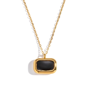 Détail d'un collier rectangulaire doré avec incrustation en émail noir sur fond blanc pur