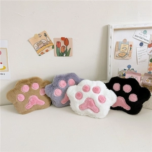 Detail view of four plush cat paw shoulder bags in brown, grey, white and black colors