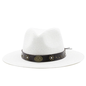 Detail of white straw fedora featuring brown leather band with bronze floral metal ornaments