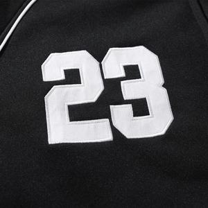 Detailed view of white number 23 embroidery on black knitted baseball jacket fabric