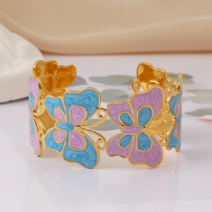 Macro shot of gold hollow-out butterfly bangle with blue and purple enamel detail