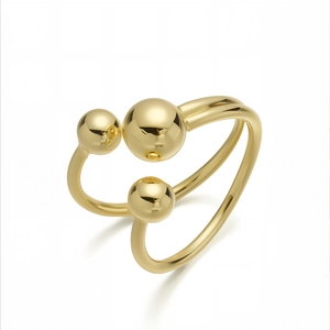 Minimalist 18K gold-plated double-ring with three polished spheres on a white background