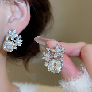 Détail du clou d'oreille fleur avec une pierre en zircone carrée et aiguille en argent