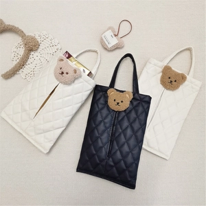Detail of white and black quilted leather car tissue box covers with cute bear ornaments