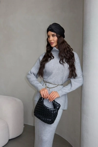 Detail of grey knitted two-piece set with high-neck sweater and matching skirt