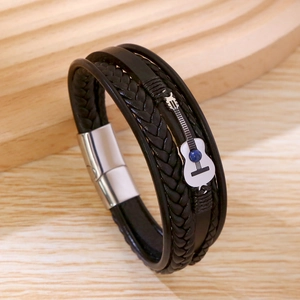 Gros plan détaillé du bracelet en cuir tressé multicouche avec un pendentif guitare métal