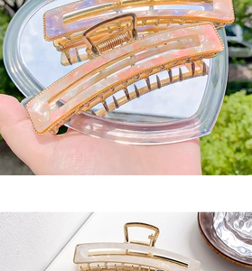 Detail of square acetate hair claws with holographic and mother-of-pearl iridescent finish