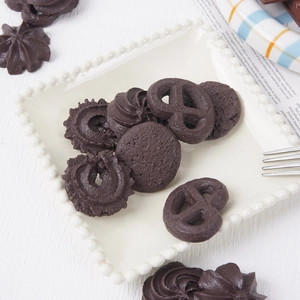 Brown chocolate cookie model assortment on a white plate with white wood background