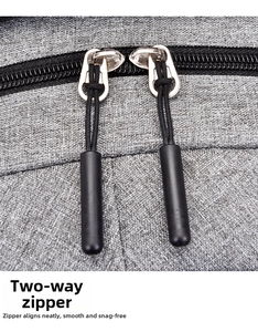 Detail view of the smooth two-way zipper and durable woven fabric on the gray backpack