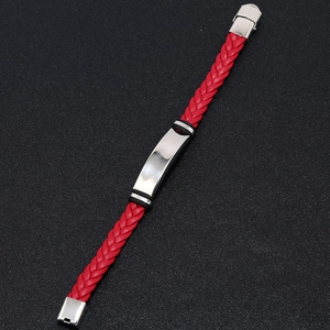 Detail of red braided leather bracelet with polished silver metal nameplate and clasp