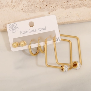 Close-up of gold stainless steel earrings set including ball studs and rhinestone hoops