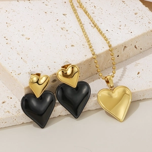 Minimalist heart jewelry set with black and gold heart earrings and a matching necklace