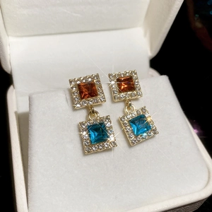 Détail de boucles d'oreilles carrées à deux couches avec pierres rouges et bleues