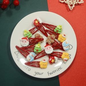 Christmas hair clips featuring Santa and snowman resin charms on a white plate