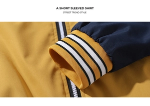 Close-up of contrast color varsity jacket featuring striped ribbed cuffs and white zipper