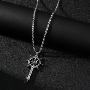 Macro d'un pendentif gouvernail et épée en acier argenté sur chaîne box