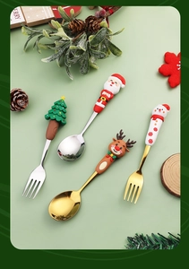 Flat lay of 4-piece Christmas cutlery set with cartoon Santa and reindeer handle decor