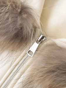 Detailed macro view of silver metal zipper and premium faux fur collar texture