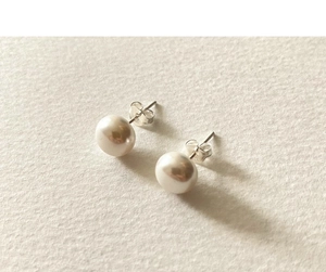 Close-up of S925 sterling silver butterfly backs and creamy white pearls with soft luster