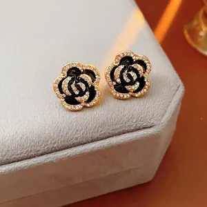 Elegant gold flower earrings with black enamel and pavé crystals in vintage style