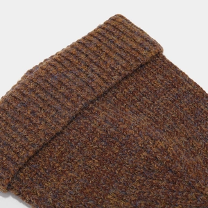 Close-up of thick ribbed knit texture on brown and purple striped winter hat and scarf