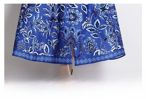 Detail of blue floral dress hem with elegant patterns and geometric lace trimming
