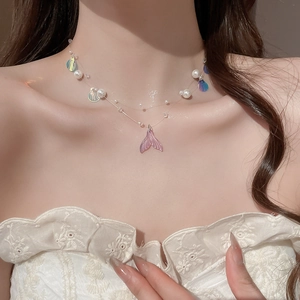 Close-up of pearl necklace with colorful shell sequins and gradient mermaid tail pendant