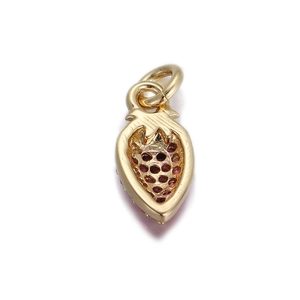 Macro shot of gold strawberry pendant with red crystal inlay and hollow design detail