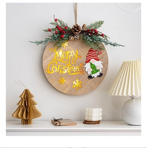 Close-up of lighted Merry Christmas wooden hanging sign with gnome and pine needles