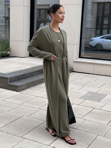 Detailed view of olive green knit cardigan texture and matching maxi dress fabric