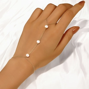 Detail of a 925 sterling silver gold finger bracelet featuring three elegant white pearls