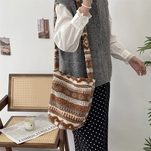 Close-up of plush lamb wool bucket bag featuring retro brown and white striped patterns