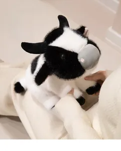 Close-up of a soft plush cow doll featuring classic black and white spots and small horns