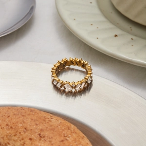 Nahaufnahme eines goldenen Edelstahlrings mit Zirkonia auf einem Metalltablett